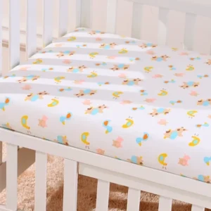 A crib with sheets and pillows on it.