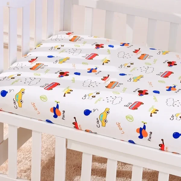 A crib with sheets and pillows on it