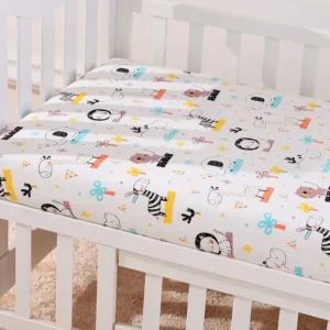 A crib with sheets and pillows on it