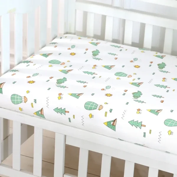 A crib with a white sheet and cactus print.