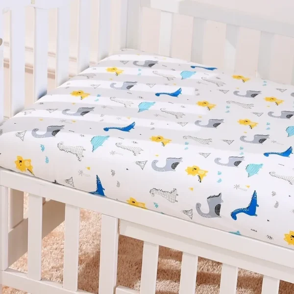 A crib with sheets and pillows on it