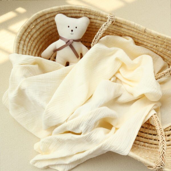 A teddy bear sitting in front of some white sheets.